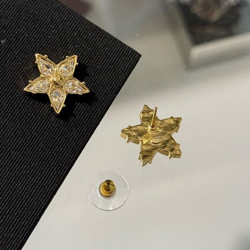 close up of CC star comet design earrings with crystal pave