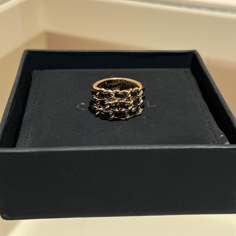 close up of three rows of CC black leather interwoven through gold chain ring 18K plated
