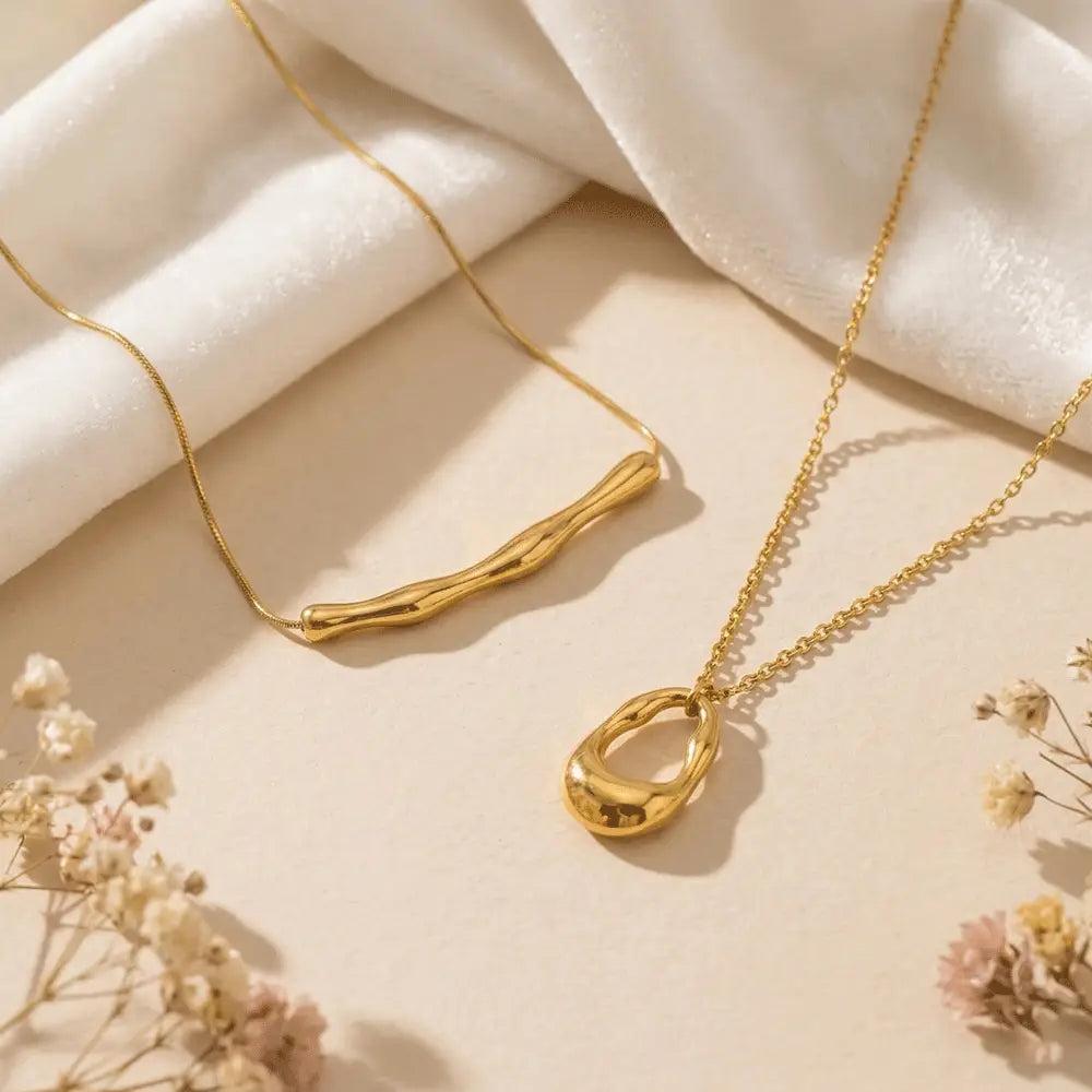 Delicate gold pendant necklace and bold statement necklace styled side by side