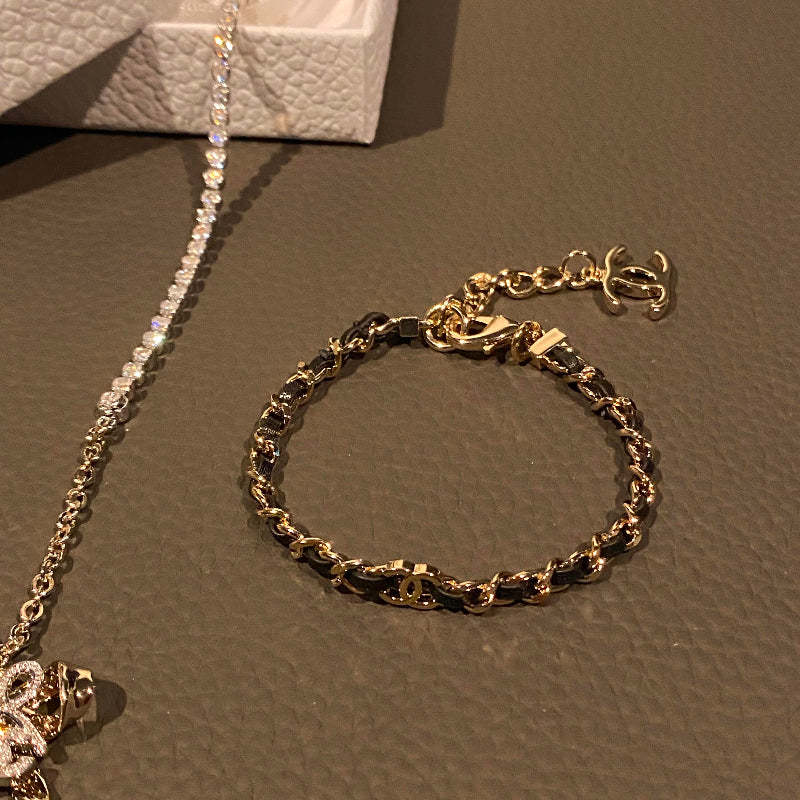 26P style CC black leather woven chain bracelet on white background