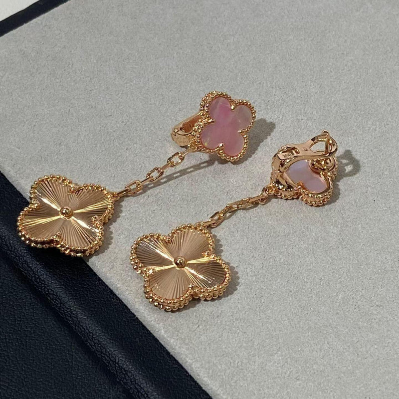 close up of two clover motifs one pink mother of pearl one sunburst guilloché engraving on rose gold earrings