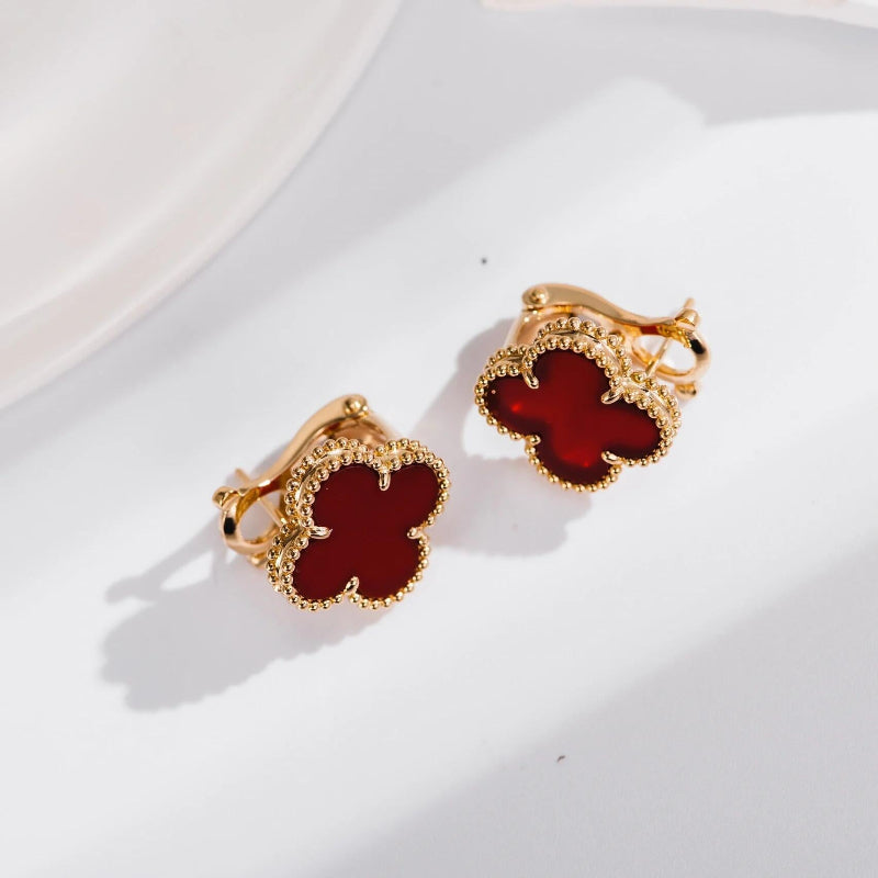 close up of warm red carnelian four leaf clover motif with gold bead contour on yellow gold earrings
