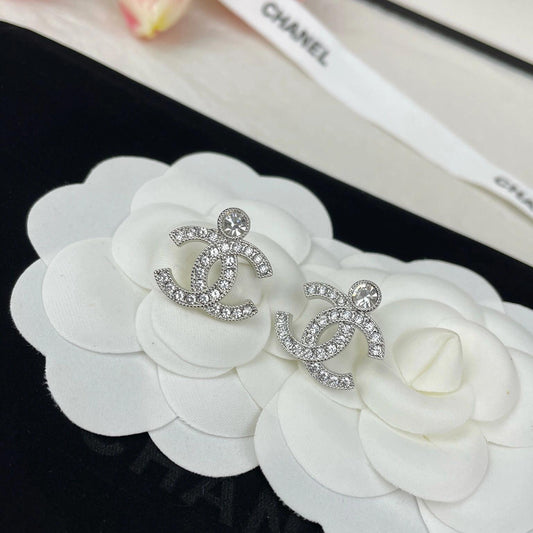 close up of full crystal pave double C earrings silver tone