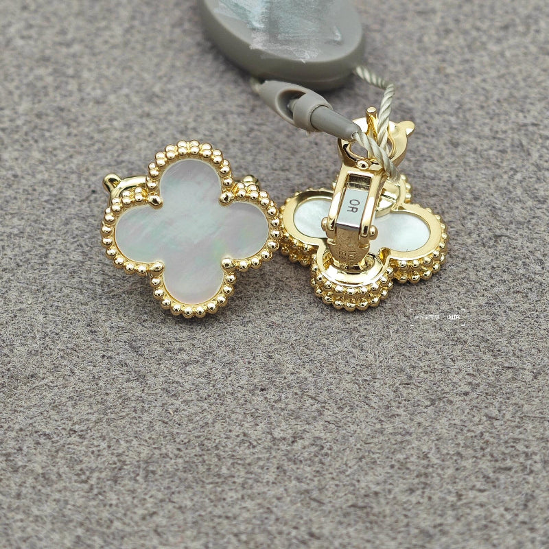 close up of iridescent white mother of pearl four leaf clover motif with gold bead contour on yellow gold earrings
