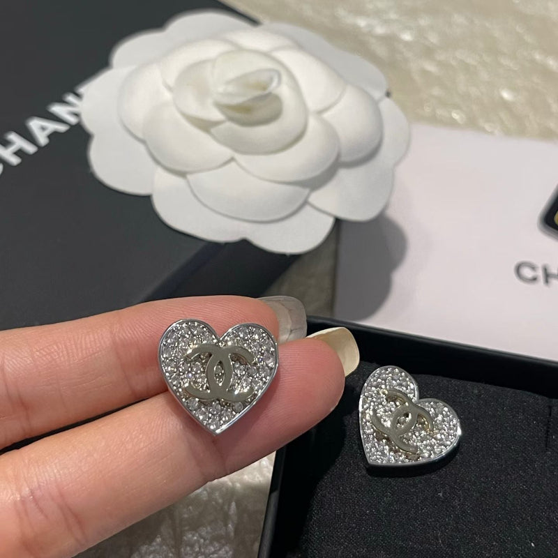 close up of full crystal pave heart earrings with champagne gold CC logo