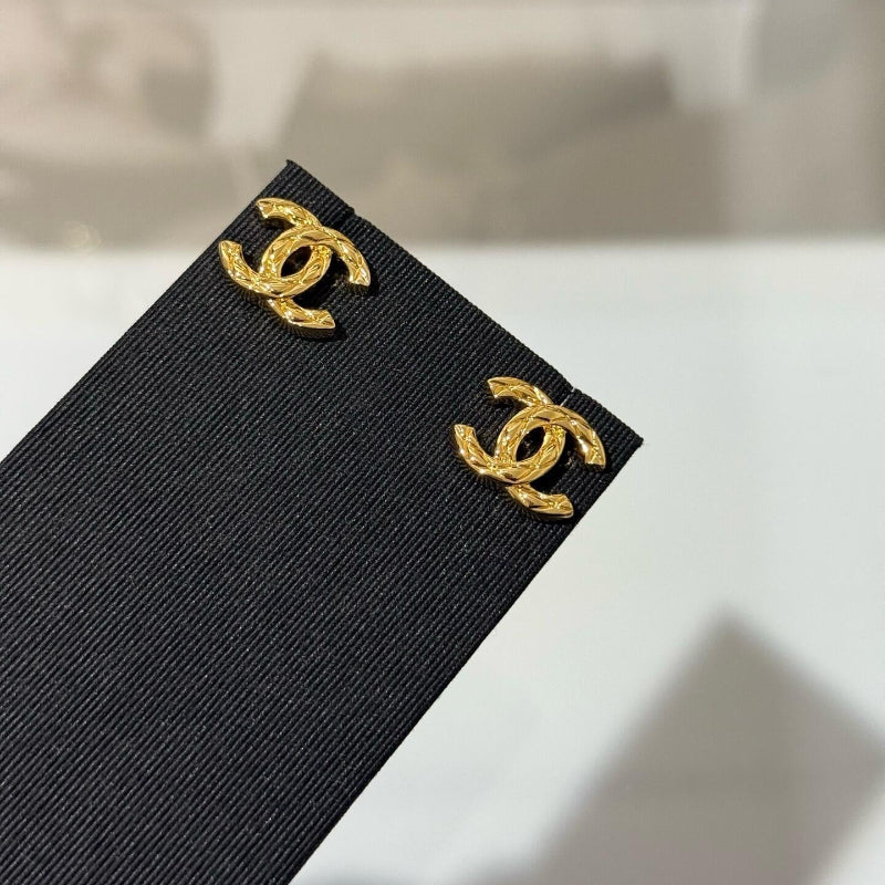 close up of quilted pattern on CC logo gold plated earrings