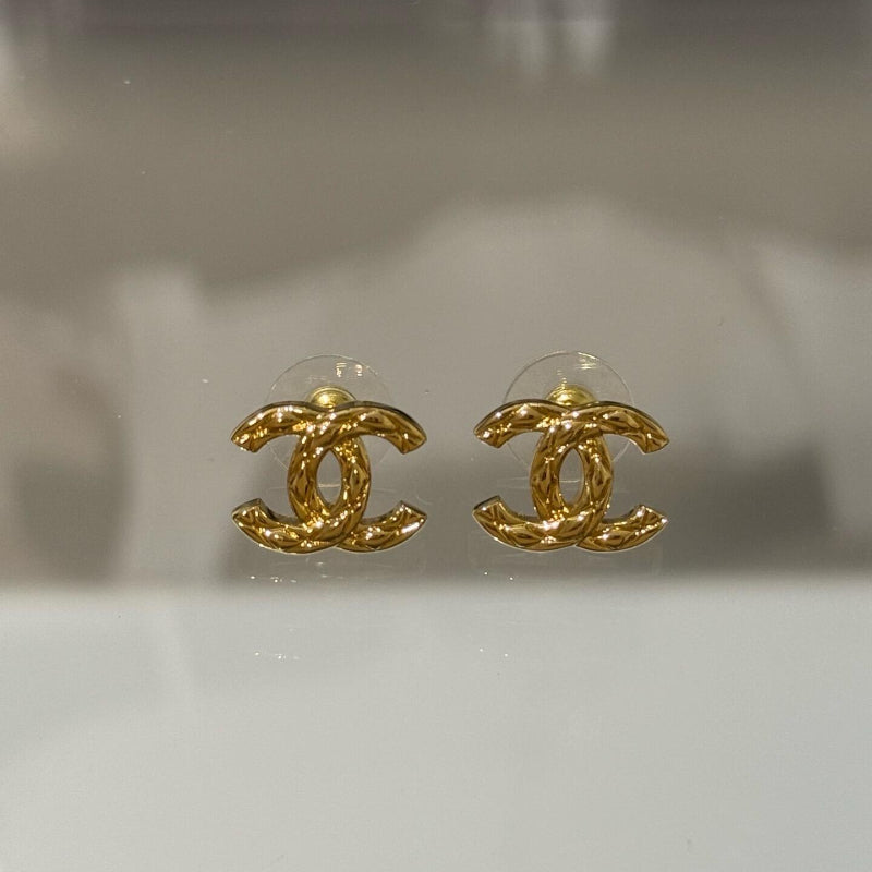 close up of quilted pattern on CC logo gold plated earrings