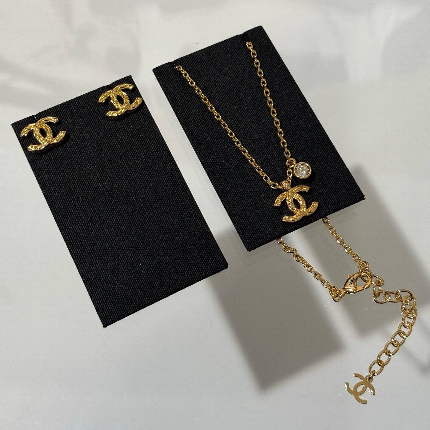 26P quilted CC gold earrings and necklace set on white background