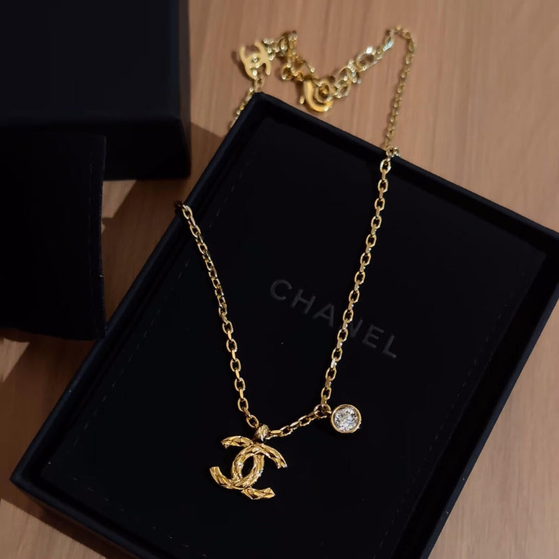 close up of quilted pattern on CC logo gold plated necklace