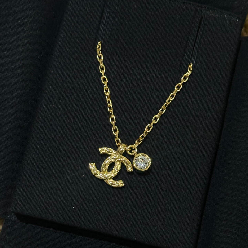 close up of quilted pattern on CC logo gold plated necklace