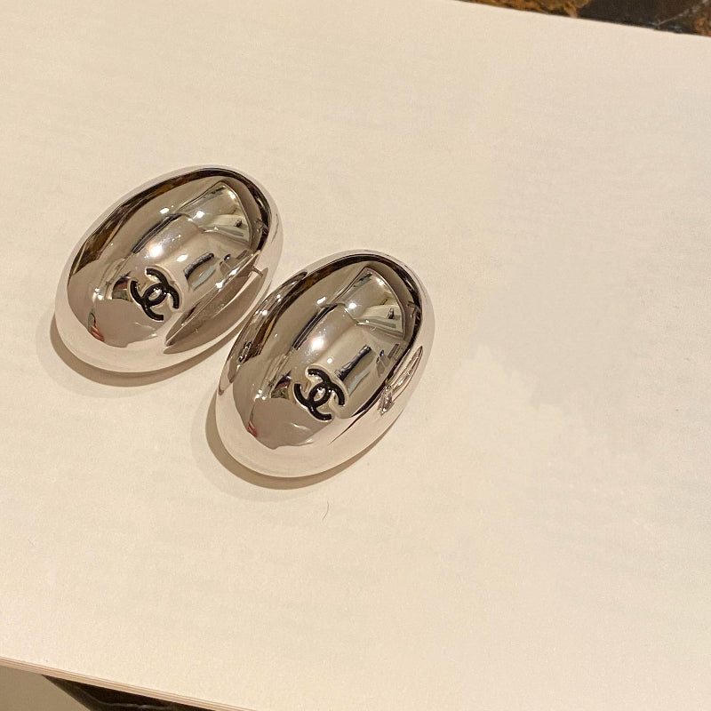 close up of quilted egg-shape pattern on CC logo stud earrings White gold