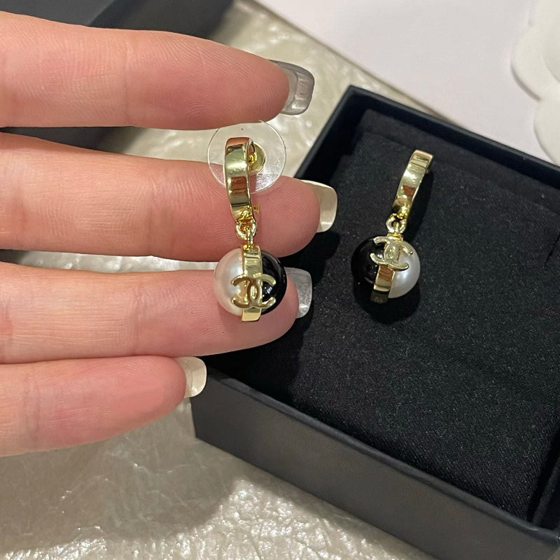 close up of CC black onyx and white pearl bead ball drop earrings 18K gold