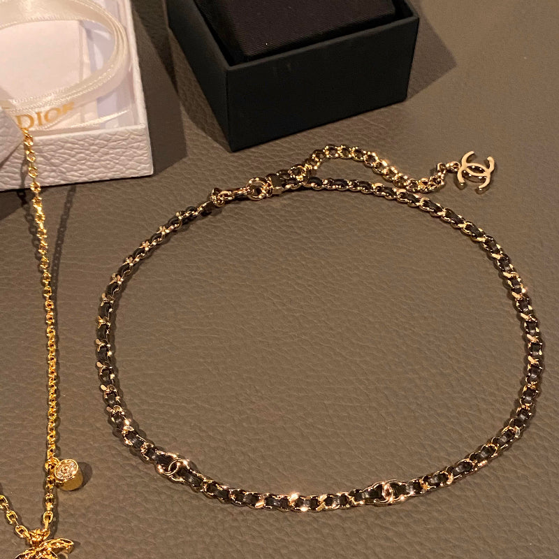close up of CC black leather interwoven with gold tone chain 18K plated