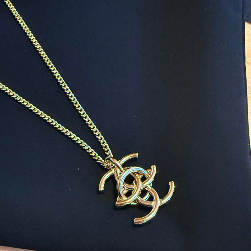 close up of interlocking CC logo pendant necklace gold tone